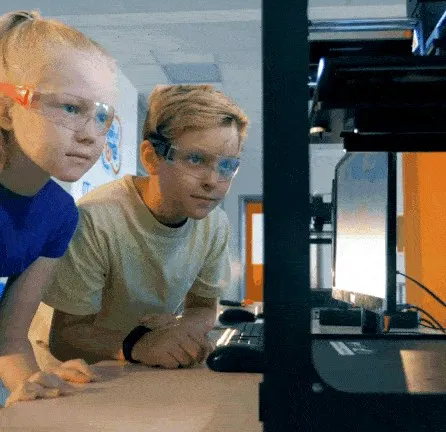 Children watching a 3D printer at work